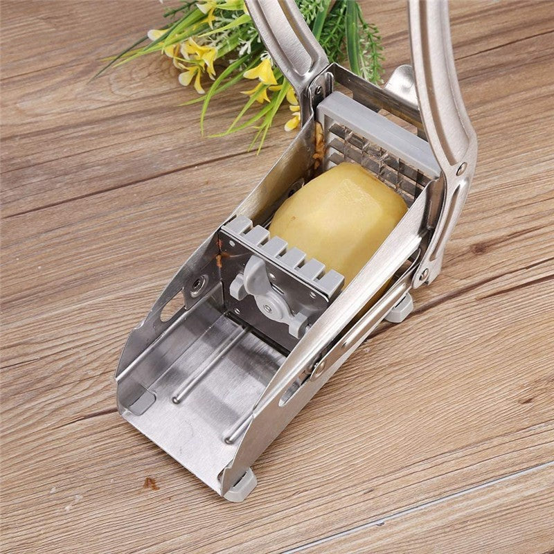 Metallic potato peeler with a potato on a wooden surface