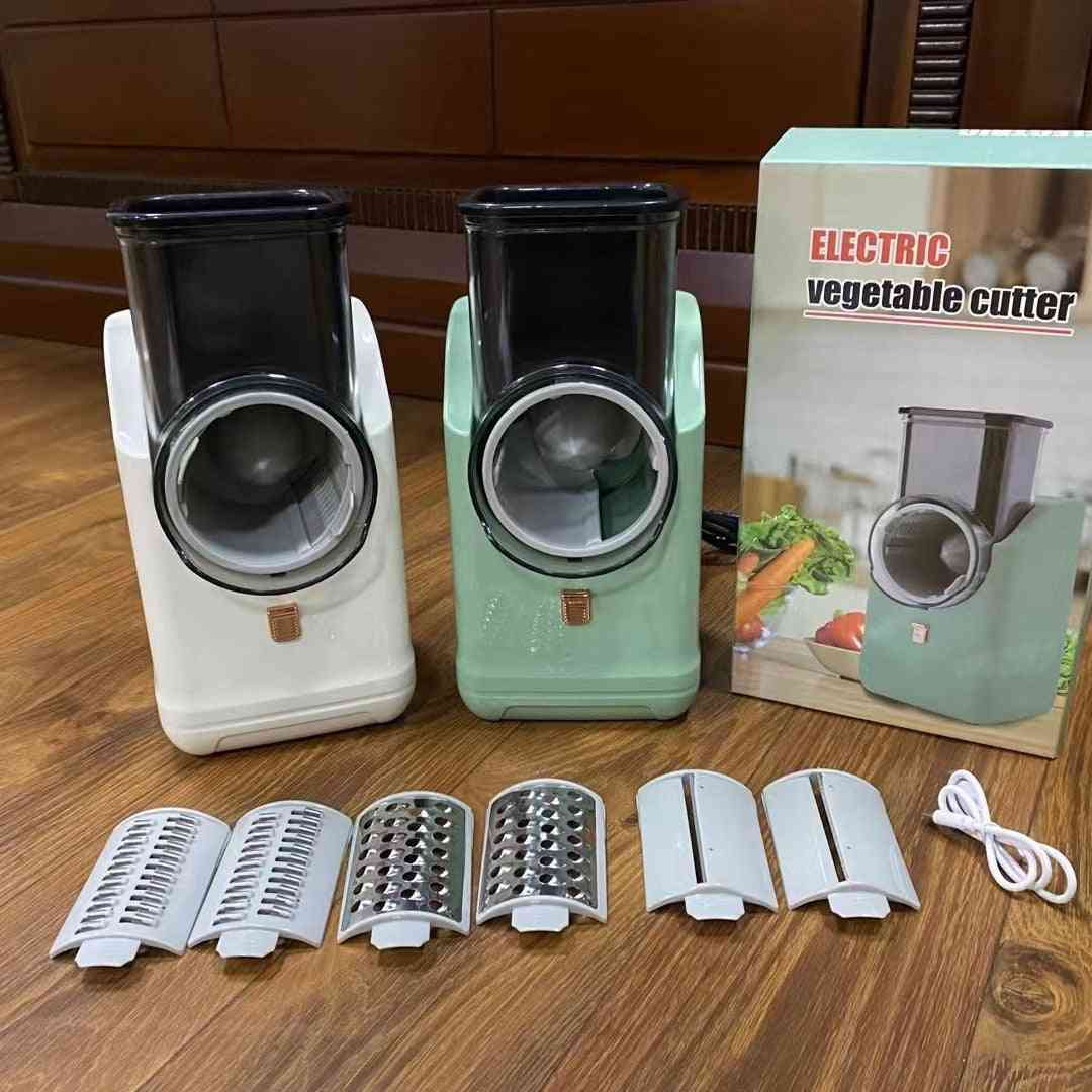 Electric vegetable cutter with attachments on a wooden surface