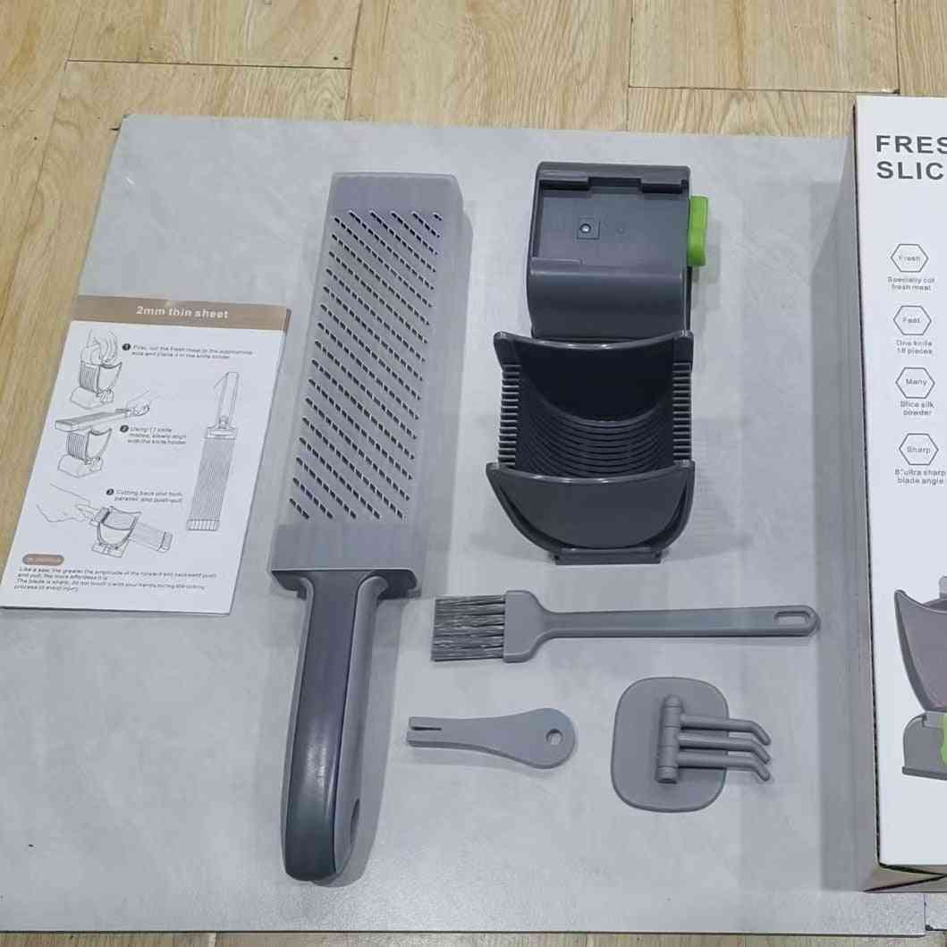 Kitchen utensils including a grater, brush, and holder on a white surface with packaging.